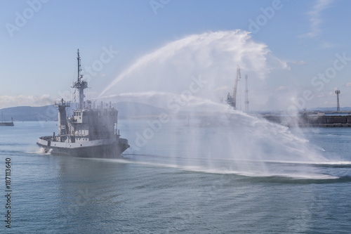 Navy firefighting ship in action. fire fighting a vessel in water from a ship.