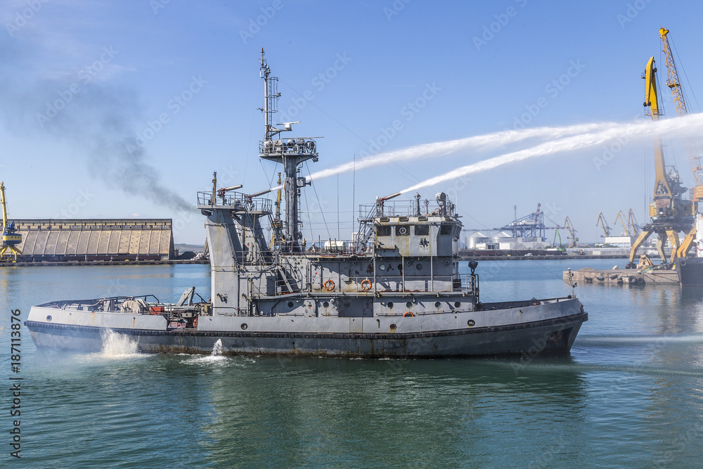 Navy firefighting ship in action. fire fighting a vessel in water from a ship.
