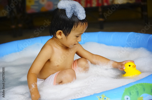 Cheerful And Active Kids Bathing In Plastic Pool