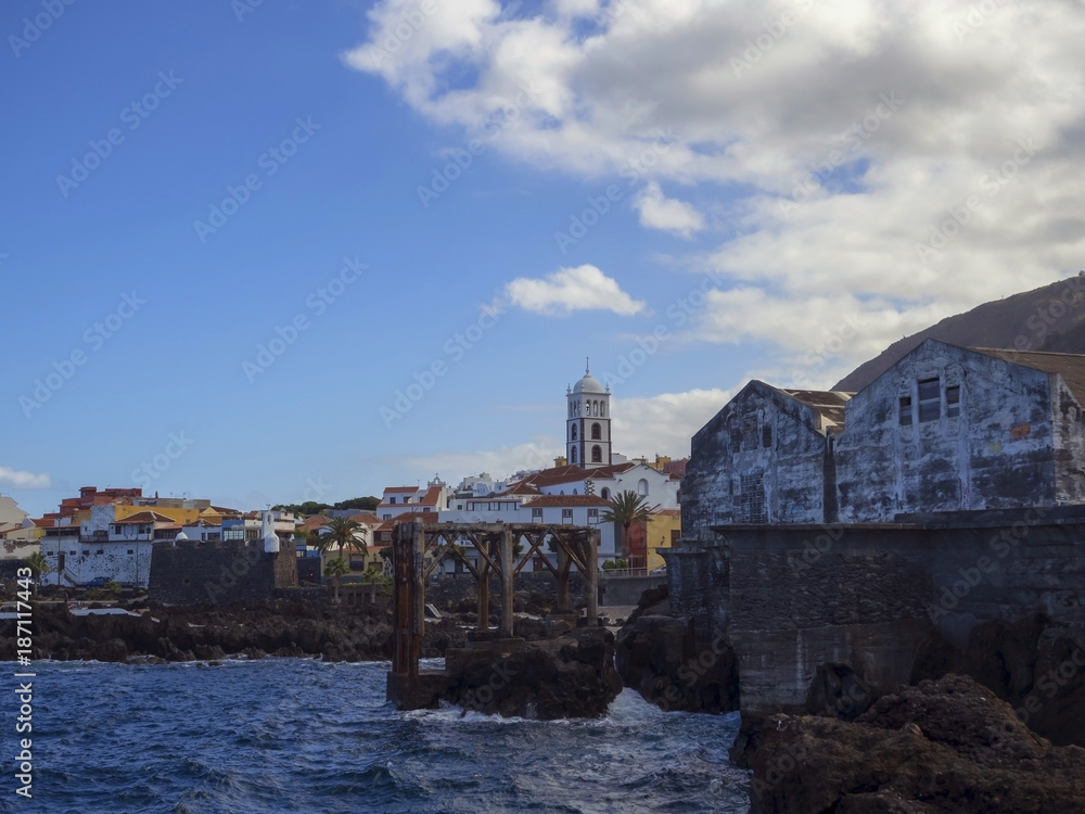 village center of Garachico panorama with sea rocka Church of Santa Ana and old fisherman dock buildings in Tenerife canary island spain and blue sky white clouds