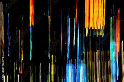 Abstract of multicolored city lights beams in motion, Moving colorful lines or light painting LED building abstraction on busy city Light trails, Rainbow and chaos black background. Vertical desigh