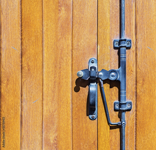 Iron lock with handle on a wooden door