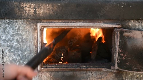 poking with a poker of coal in the furnace