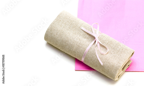 Cloth bundle and pink paper bag isolated on white
