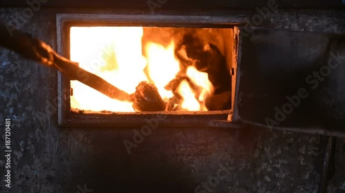 poking with a poker of coal in the furnace