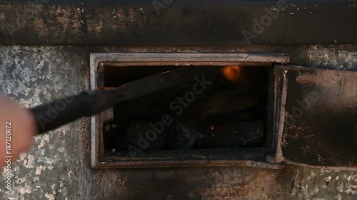 poking with a poker of coal in the furnace