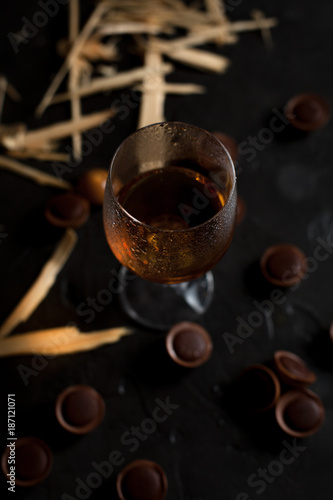 glasses with wine, chocolate and fruit on a dark background
