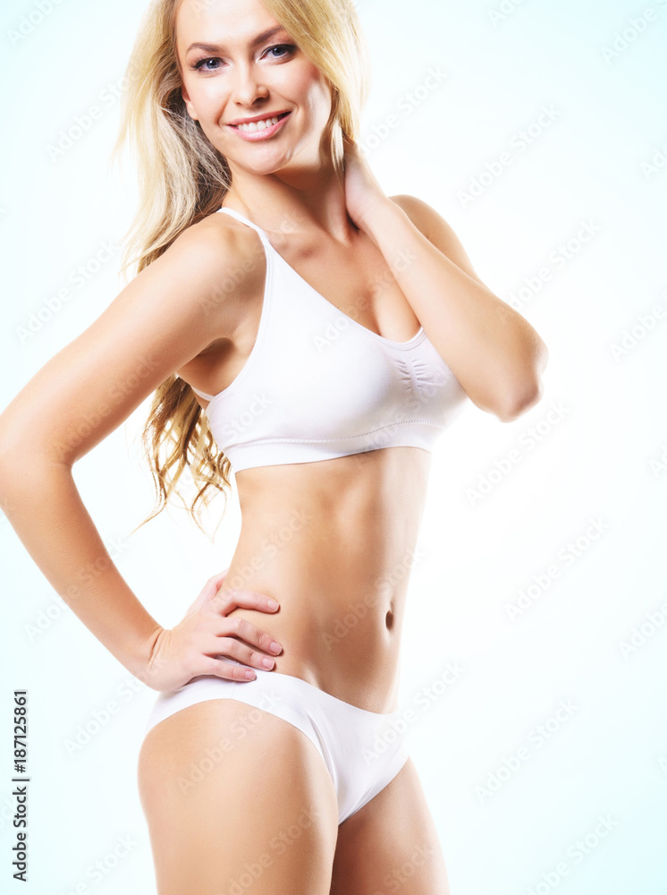 Fit and sporty girl in white underwear. Beautiful and healthy woman posing. Sport, fitness, diet, weight loss and healthcare concept. Fit and sporty girl in white underwear. Beautiful and healthy woman posing. Sport, fitness, diet, weight loss and healthcare concept.