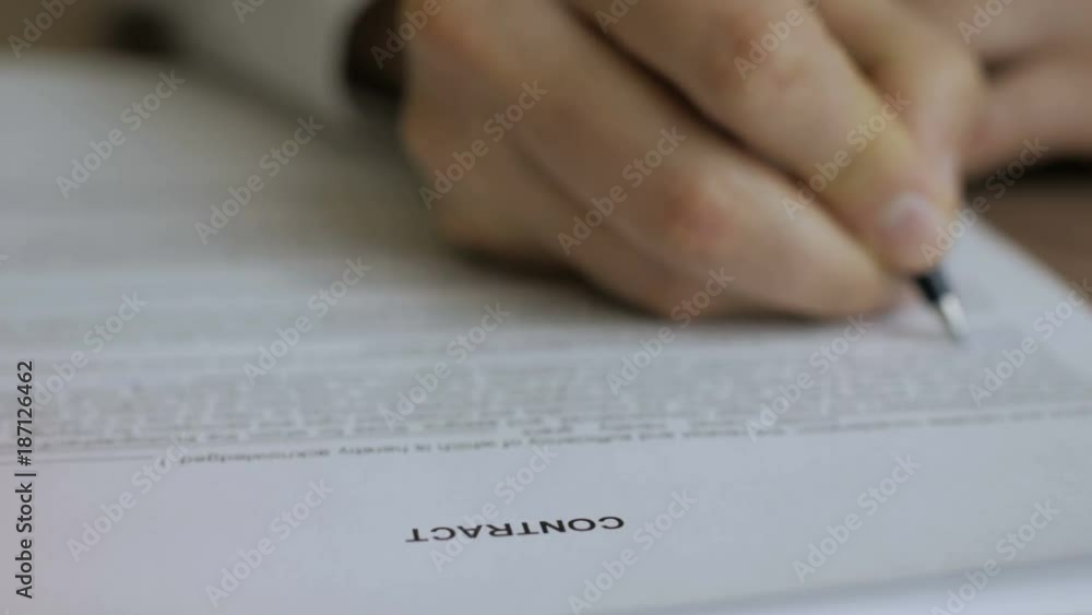 Businessman signing business contract agreement, close up of male hand with pen writing signature. The man corrects and fills the document. Businessman signing business contract agreement, close up of male hand with pen writing signature. The man corrects and fills the document.