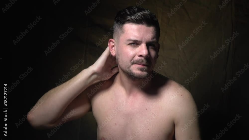 Slow-motion shooting of a man that combs his hair and stares at the camera Slow-motion shooting of a man that combs his hair and stares at the camera