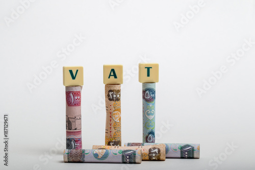 Stacks of  dirham banknotes with the letters VAT  (Value Added Tax) isolated on white background