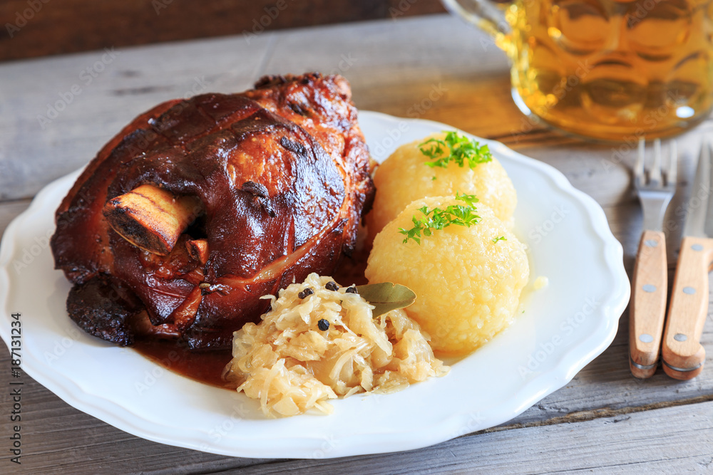 Grillhaxe mit Sauerkraut und knödeln StockFoto Adobe Stock
