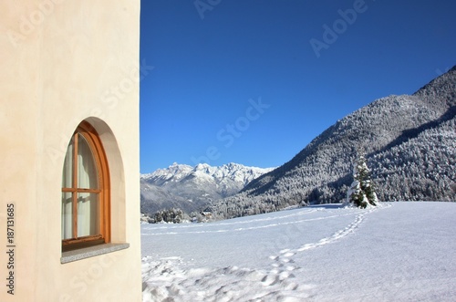 Window corner of an alpine house. Snow landscape. Trentino, Italy photo