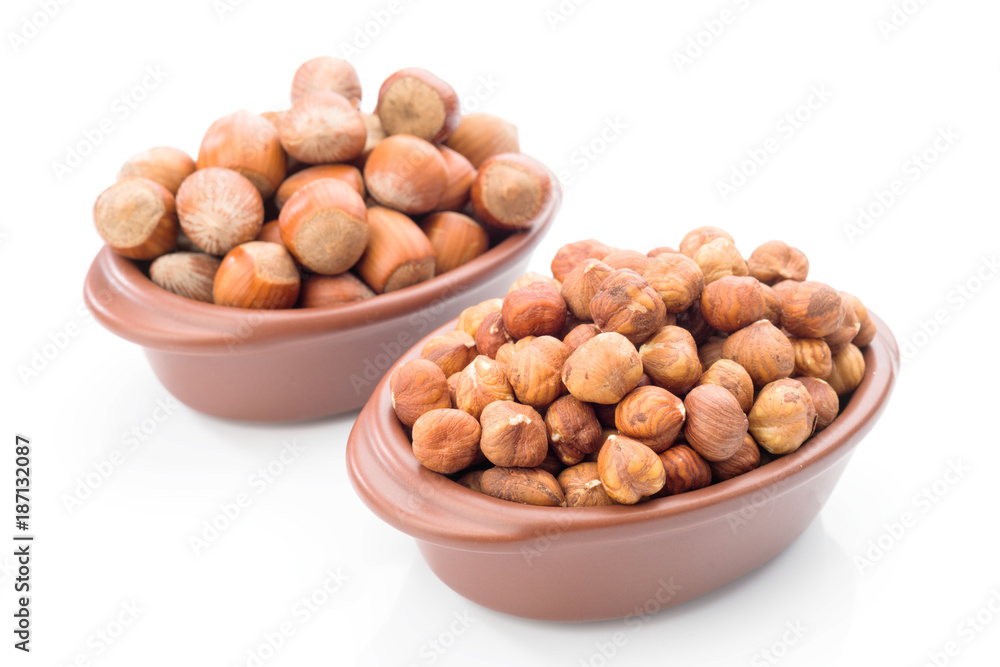 hazelnuts in clay bowl on white background hazelnuts in clay bowl on white background