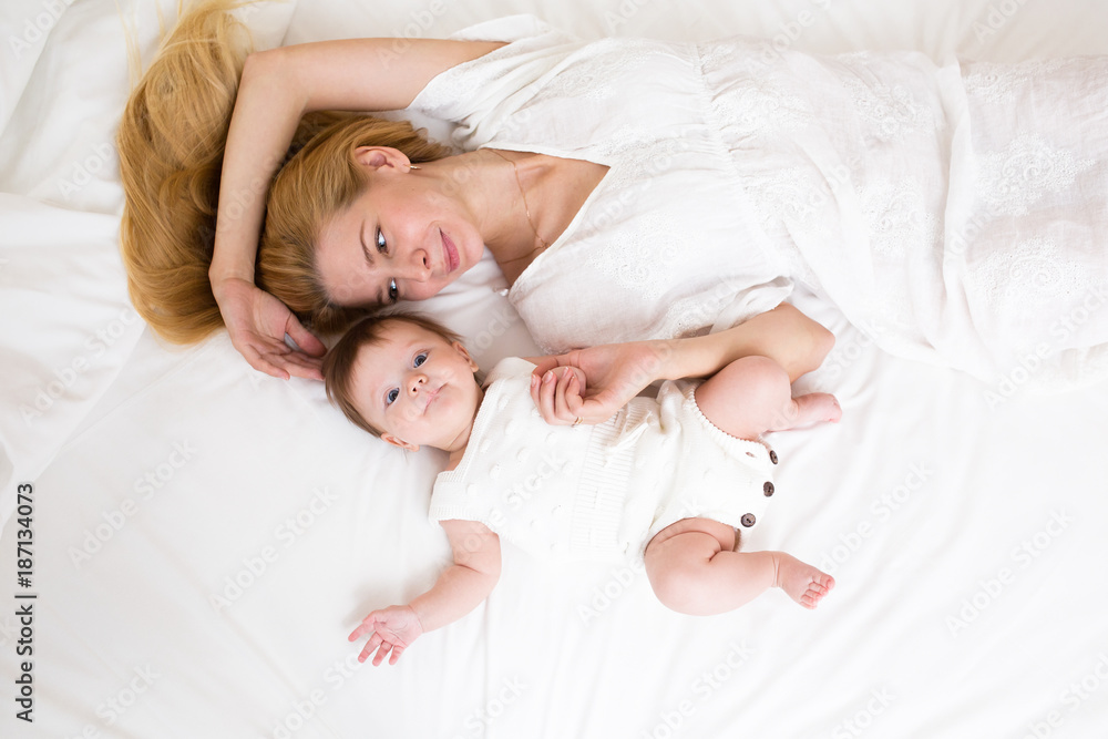 happy loving family. mother playing with her baby in the bedroom, view from above. happy loving family. mother playing with her baby in the bedroom, view from above.
