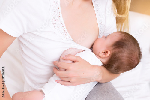 mother breastfeeding and hugging baby. Young mom breast feeding her newborn child. Lactation infant concept. Baby eating milk before sleep. Mother feed her three month baby daughter with breast milk