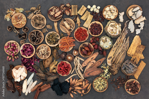 Large selection of traditional chinese herbs used in alternative herbal medicine in wooden bowls and loose. Top view. 