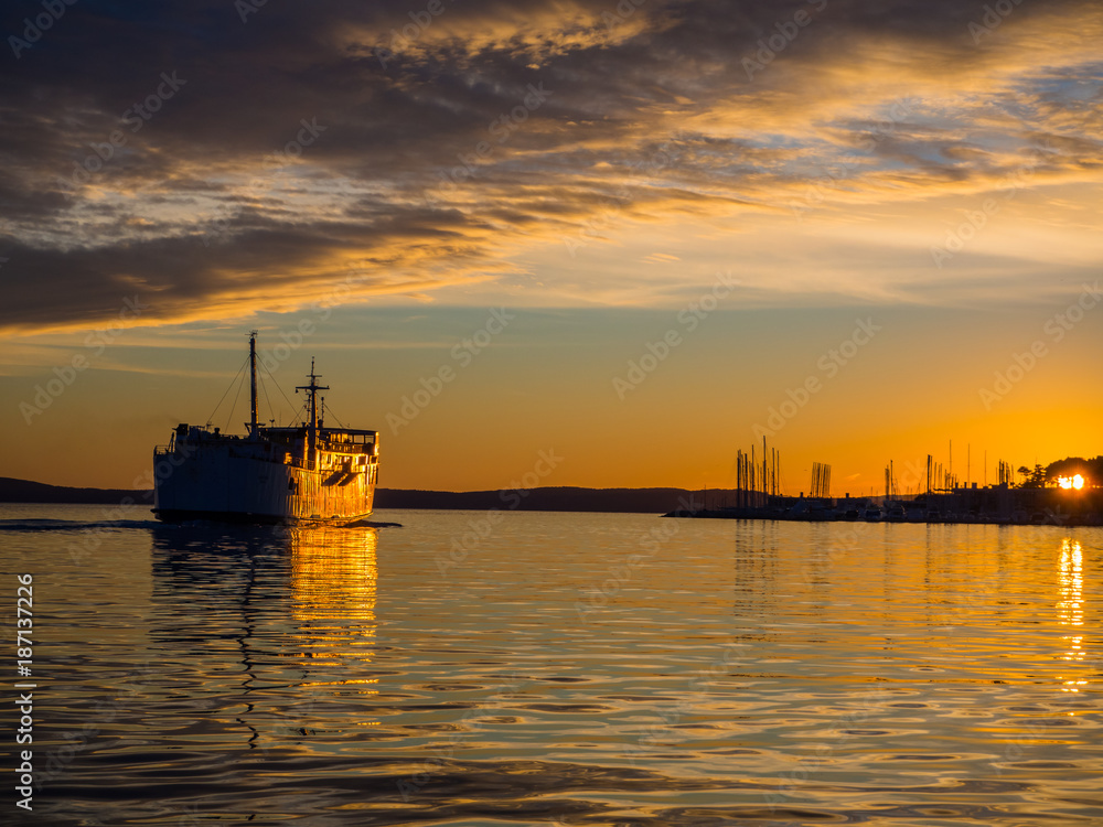 Fototapeta premium Big passanger ship sailing into the sunset.