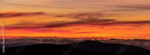 Fire in the sky. A strong play of colors with a strong red glow in the sky over the mountains. Chemtrails created this spectacle. Concept: weather or sunset / sunrise