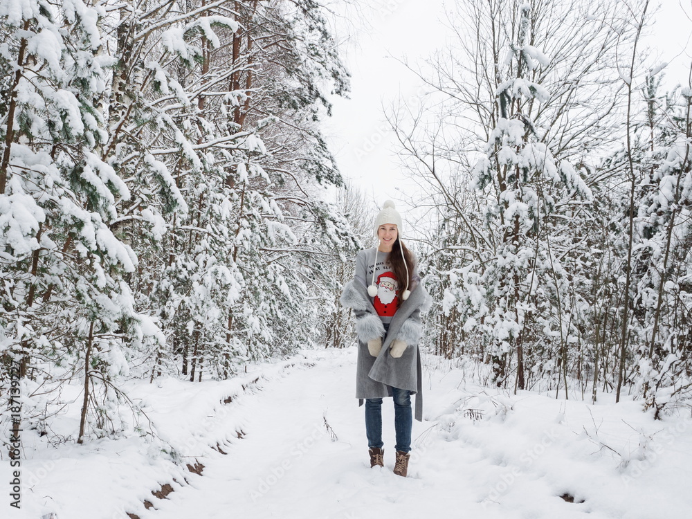 Cute and happy girl in a beautiful snowy forest
