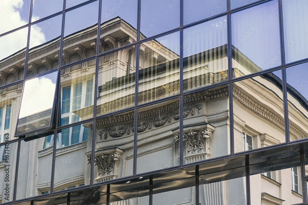 Contrast of architecture on Warsaw street. Reflection old building in modern glass and steel construction. Contrast of architecture on Warsaw street. Reflection old building in modern glass and steel construction.