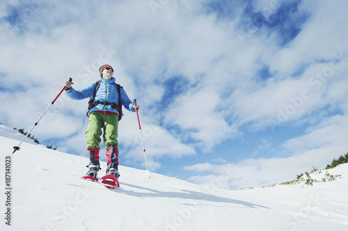 Hiker in winter mountains. Man with backpack trekking in mountains. Winter hiking.