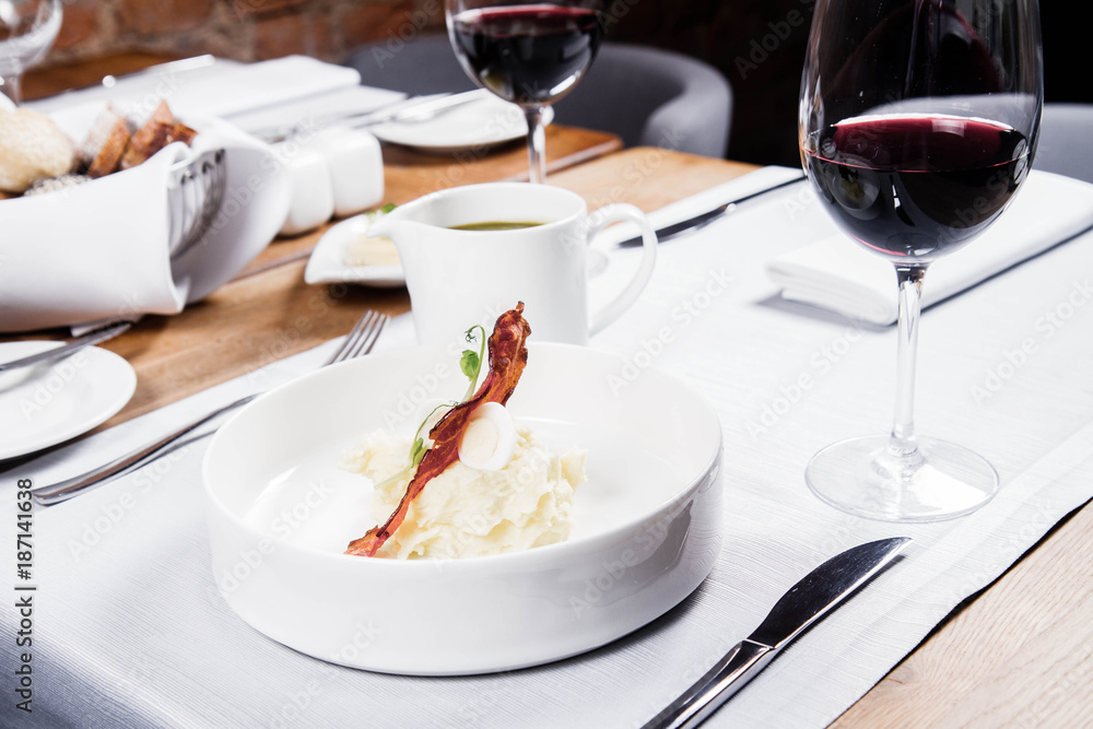 Cream of sorrel and green vegetables soup with quail egg, sour cream, mashed potatoes and crispy bacon served in a jug in a restaurant Cream of sorrel and green vegetables soup with quail egg, sour cream, mashed potatoes and crispy bacon served in a jug in a restaurant