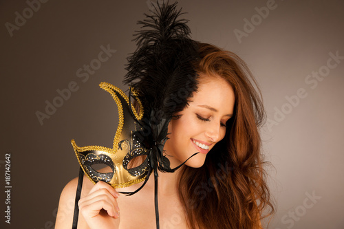 atractive young woman with venice mask studio portrait