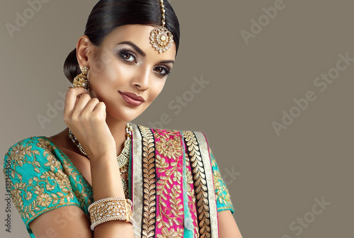 Portrait of beautiful indian girl. Young hindu woman model with kundan jewelry set. Traditional India costume lehenga choli or sari
