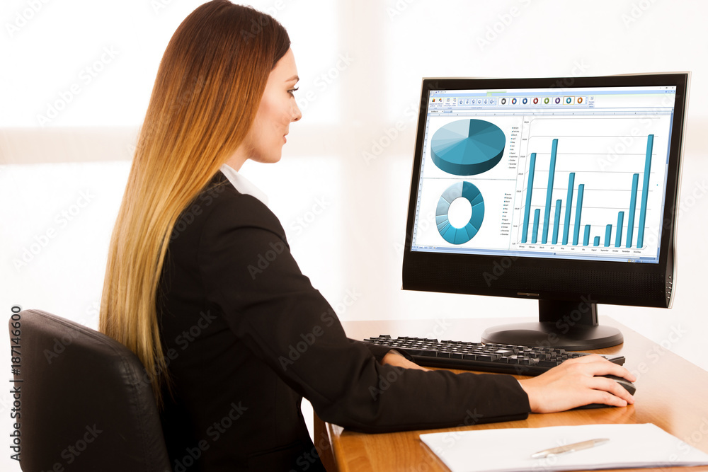 beautiful young business woman works in her office with blank copy space on her monitor beautiful young business woman works in her office with blank copy space on her monitor