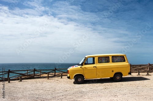 Traveling in Europe on a yellow car. Summer, heat, freedom. On the shore of the ocean. Portugal, minivan, romance