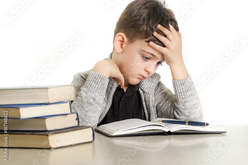 Slika na platnu Studio portrait of young boy struggling with his homework - learning difficultie