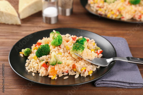 Plate with rice pilaf and broccoli on wooden table