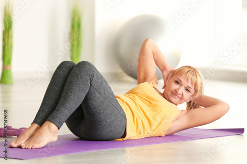 Sporty mature woman training at home