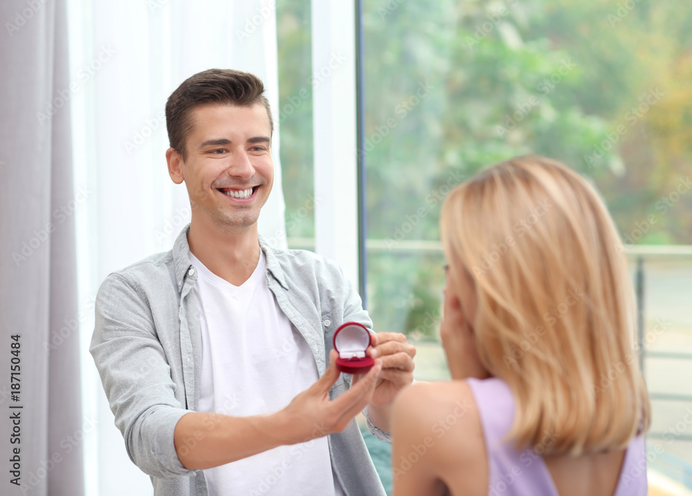 Man with engagement ring making proposal of marriage to woman at home Man with engagement ring making proposal of marriage to woman at home