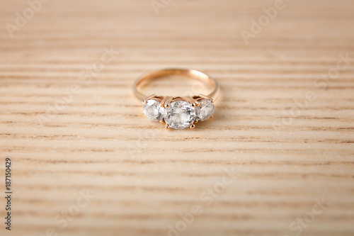 Beautiful engagement ring on wooden background