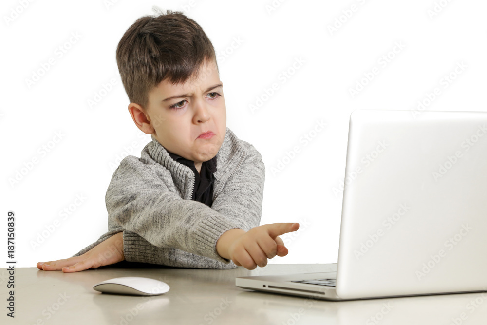Studio portrait of upset schoolboy in front of lap top Studio portrait of upset schoolboy in front of lap top