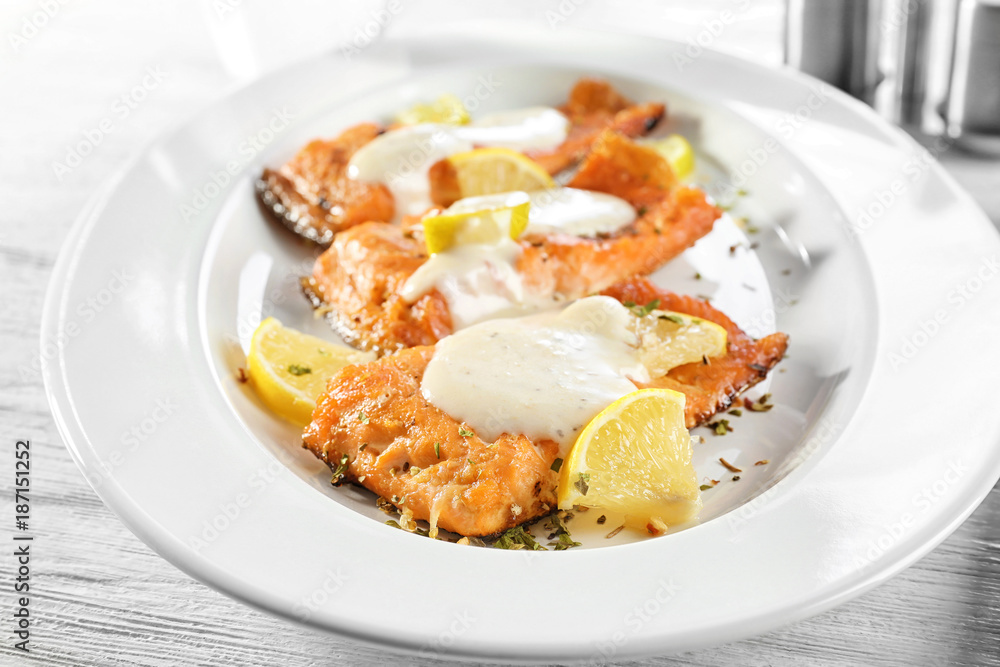 Tasty rainbow trout fillets with sauce on plate