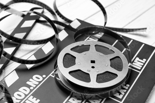 Movie clapper and reel on light background, closeup