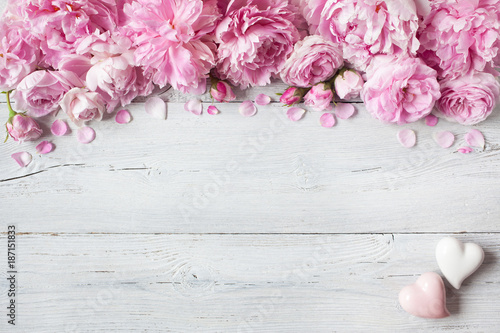 Fototapeta Naklejka Na Ścianę i Meble -  Pink peonies and roses, hearts on a wooden background