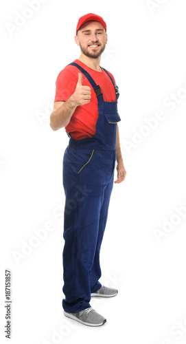 Handsome auto mechanic showing thumb-up gesture on white background