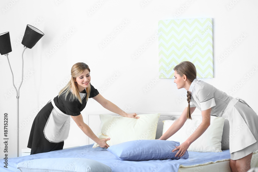 Obraz premium Chambermaid in uniform teaching trainee indoors