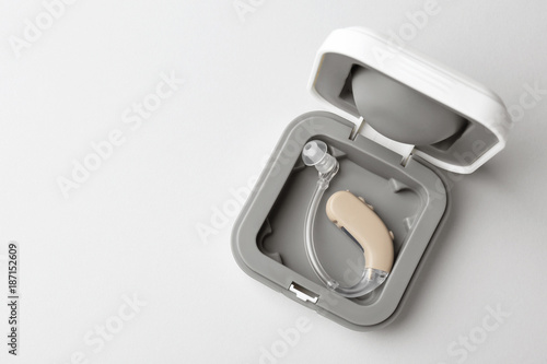 Box with hearing aid on light background