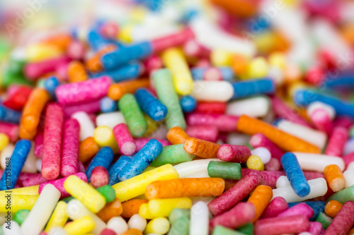 Closeup of a pile of colourful sugar sprinkles (cake decor), side view