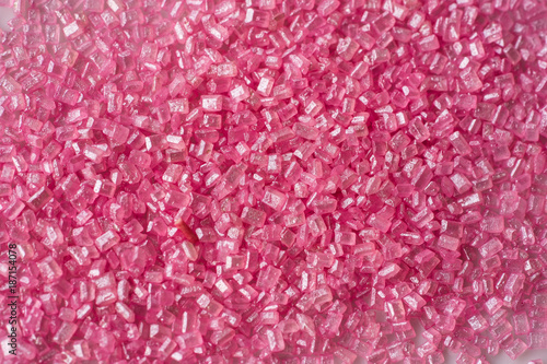 Closeup of a pile of pink sugar crystals (cake decor), from above