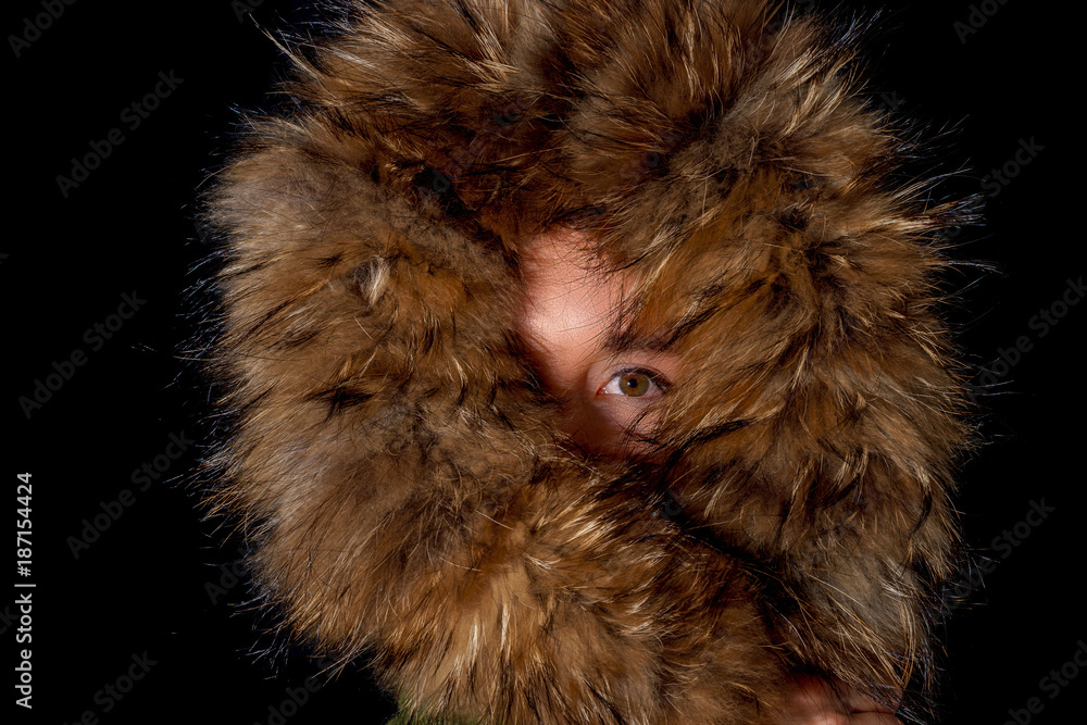 Sexy fashion woman in fur hood, hiding half of her face Sexy fashion woman in fur hood, hiding half of her face