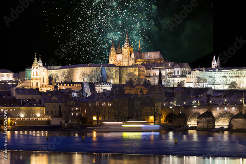 Fireworks above night colorful snowy Prague gothic Castle with Charles Bridge, Czech republic