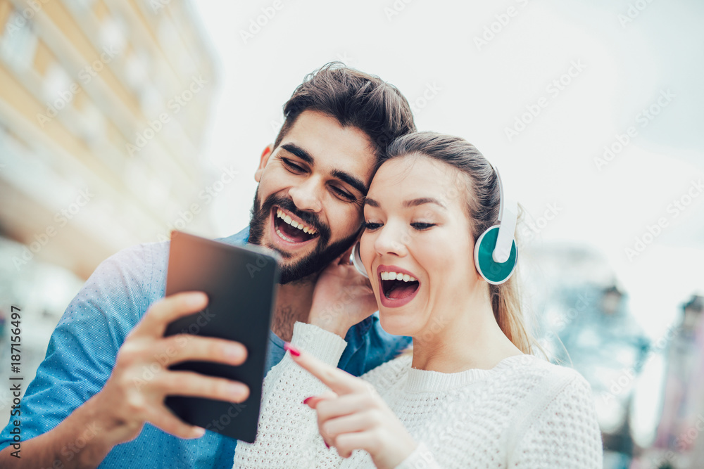 Young attractive couple looking at digital tablet.