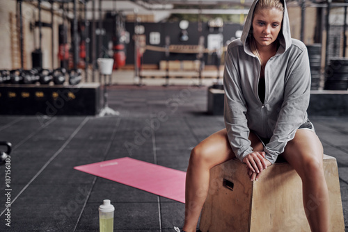 Focused young woman sitting in a gym after working out