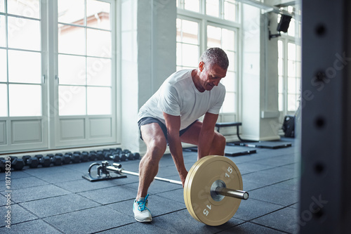 Fotografía Senior man in sportswear weightlifting alone in a gym